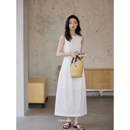 Sleeveless Maxi Dress Paired With a Woven Straw Handbag